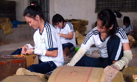 Ngoài giờ học, các học sinh còn tham gia lao động sản xuất tại xưởng làm giấy bạc.            Ảnh: T.MINH 