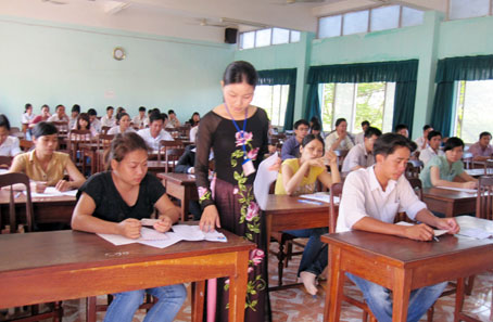 Giám thị kiểm tra giấy báo thi của thí sinh. Ảnh: N. Thư