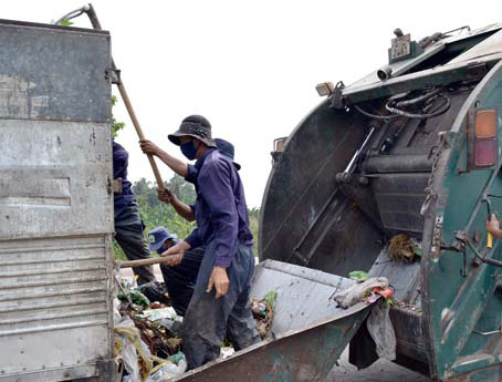 Công nhân Xí nghiệp môi trường Biên Hòa đang chuyển rác thu gom từ các hộ và xe chuyên dụng. Ảnh: V.N