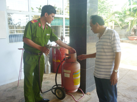 Cảnh sát PCCC huyện Trảng Bom kiểm tra, hướng dẫn chủ doanh nghiệp kinh doanh xăng dầu bảo quản phương tiện chữa cháy. Ảnh: Đ.Việt