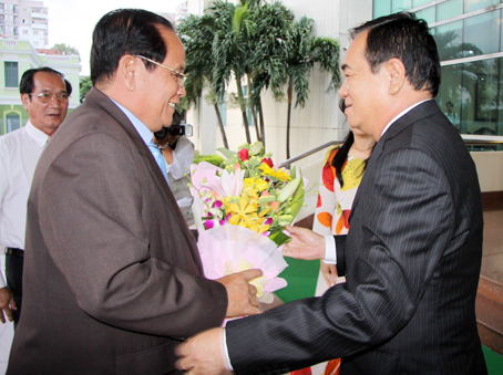 Secretary Tran Dinh Thanh presents flowers to Chairman Nam Tum.