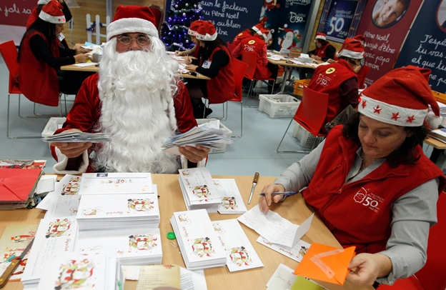 Một nhân viên bưu điện mặc đồ ông già Noel làm việc trong ngày khai trương văn phòng ông già Noel ở bưu điện Libourne, Pháp, 06/11/2012. Từ năm 1962, bưu điện này đã gửi thư trả lời cho trẻ em ở 160 quốc gia khác nhau trên thế giới. Khoảng 1,4 triệu lá thư tay và 180.000 email đã được trả lời trong kỳ Giáng sinh năm ngoái.