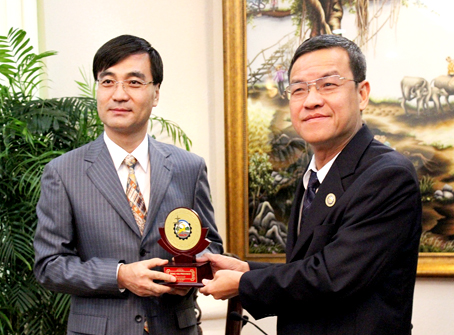 Chairman Dinh Quoc Thai presents a picture made with rice showing Tran Bien Temple of Literature to Gyeongnam province’s Governor.