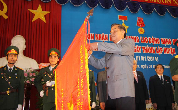 Vice Chairman Tran Minh Phuc pins the First Class Labor Medal on traditional flag of the Dong Nai university
