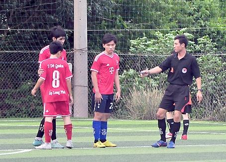 Trọng tài Nguyễn Thế Hải (bìa phải) xử lý tình huống trên sân bóng.