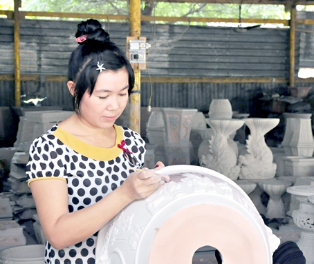Bà Mai Thị Minh Nguyệt chấm men chiếc chậu cỡ trung.