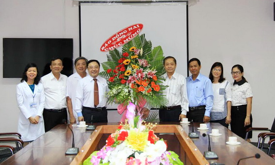 Dong Nai Newspaper’s Editor-in-Chief Tran Huy Thanh ( 4th, left) gives flower bunch to congratulate Dong Nai General Hospital