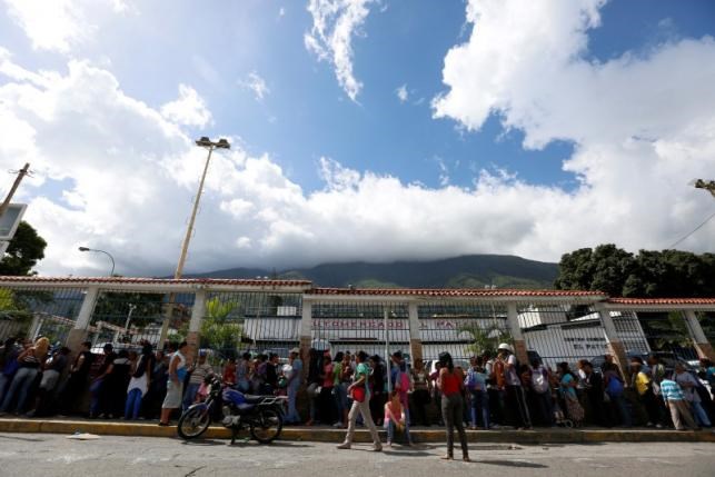 Người dân xếp hàng bên ngoài một siêu thị ở Caracas. (Nguồn: Reuters)