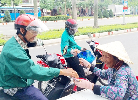 Người đi đường ghé mua vé số truyền thống của bà Nguyễn Thị Hạnh trên đường Nguyễn Ái Quốc (TP.Biên Hòa). Ảnh: P.Uyên