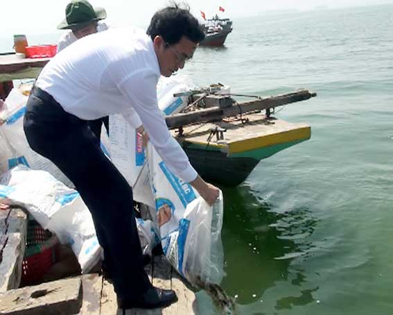 Secretary Tran Dinh Thanh drops fish into Tri An Lake.