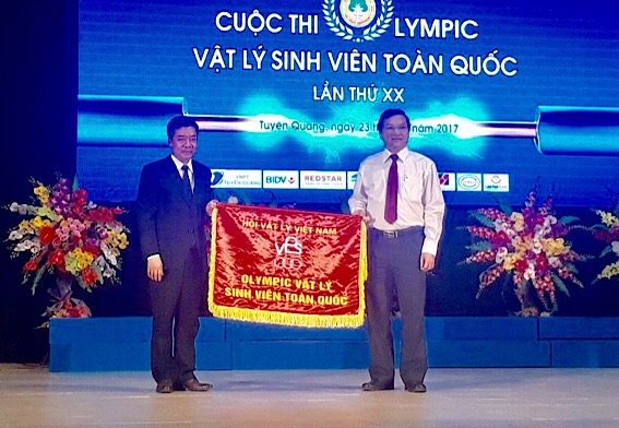 Tiến sĩ Trần Minh Hùng, Hiệu trưởng Trường đại học Đồng Nai nhận Cờ đăng cai chức Cuộc thi Olympic vật lý sinh viên toàn quốc lần thứ XXI năm 2018. (Ảnh: CTV)