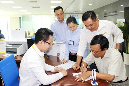 Ông Trần Mai Anh, phường Xuân Hòa, TX.Long Khánh (người ngồi bên phải) là vị khách đầu tiên đến làm thủ tục tại Trung tâm hành chính công tỉnh Đồng Nai.