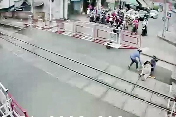 2 nhân viên đường sắt băng ra cứu bà cụ thoát chết trong gang tấc