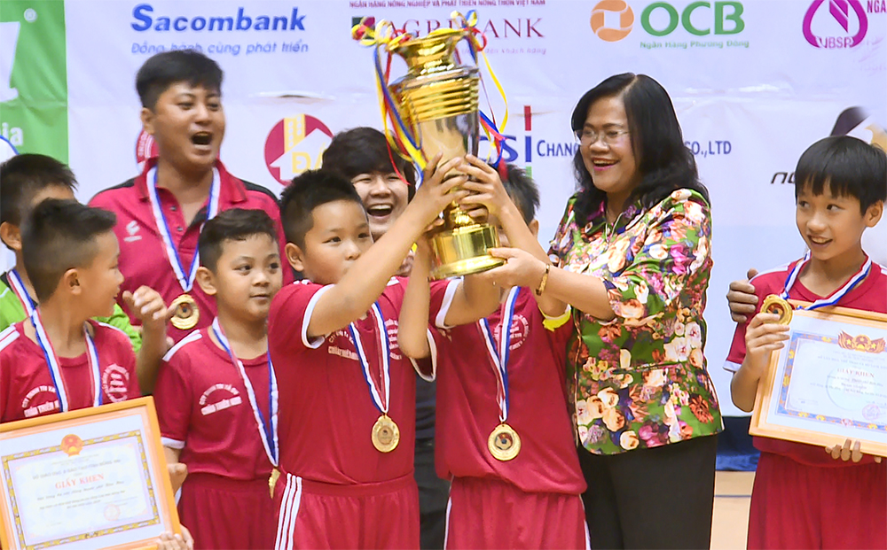 Vice Chairwoman Nguyen Hoa Hiep of the provincial People's Commitee presents the trophy to the winners.