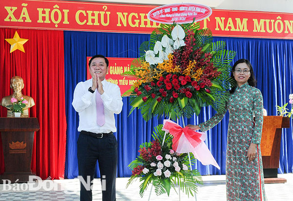 Ông Nguyễn Thanh Lâm, Phó Chủ tịch UBND huyện Vĩnh Cửu tặng hoa chúc mừng năm học mới cho Trường tiểu học Sông Mây. Ảnh: Triệu Phong
