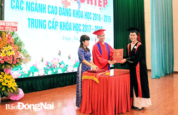 Hiệu trưởng Trường cao đẳng Y tế Đồng Nai Nguyễn Hồng Quang  trao bằng tốt nghiệp cho các sinh viên. Ảnh: B. Nhàn
