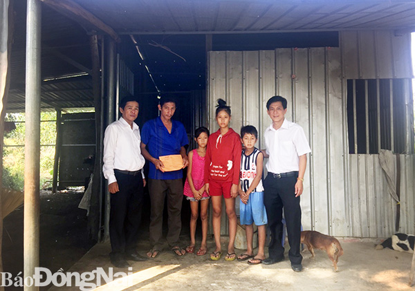 Phó tổng biên tập Báo Đồng Nai (ngoài cùng bên trái trao tặng 16 triệu đồng cho gia đình ông Tuấn