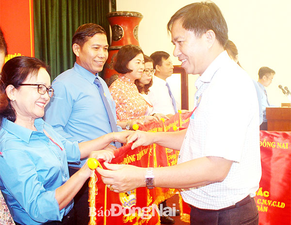Chị Nguyễn Thị Út đại diện cho Công đoàn cơ sở nhận cờ thi đua xuất sắc của Liên đoàn Lao động tỉnh dành cho tập thể tại Hội nghị tổng kết phong trào đua yêu nước trong công nhân viên chức lao động toàn tỉnh được tổ chức năm 2019. Ảnh: Thảo Lâm