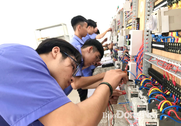 Em Vũ Việt Anh, học sinh nghề điện lạnh, Trường cao đẳng Nghề công nghệ cao Đồng Nai (bìa trái) trong tiết thực hành