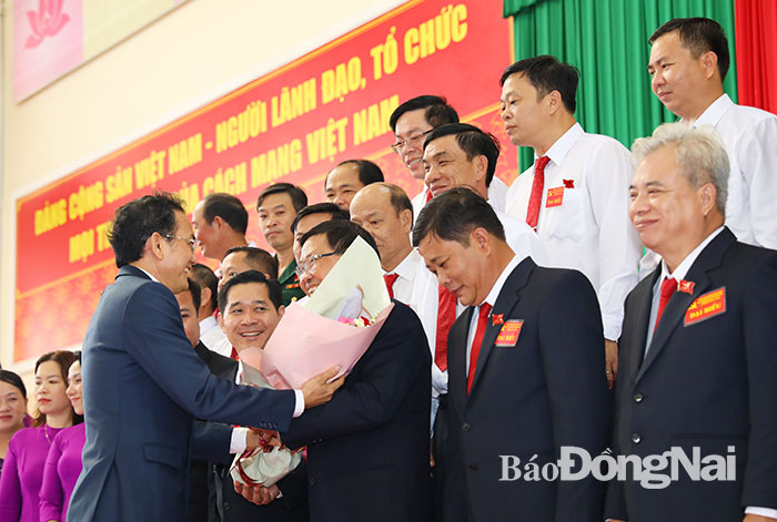 Ủy viên Ban TVTU: Phó chủ tịch UBND tỉnh Võ Văn Chánh tặng hoa chúc mừng Bí thư Huyện ủy Trần Bá Đạt