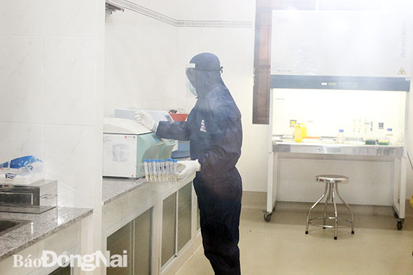 Nhân viên y tế Trung tâm Kiểm soát bệnh tật tỉnh thực hiện xét nghiệm virus SARS-CoV-2 trong điều kiện nghiêm ngặt. Ảnh: Hạnh Dung