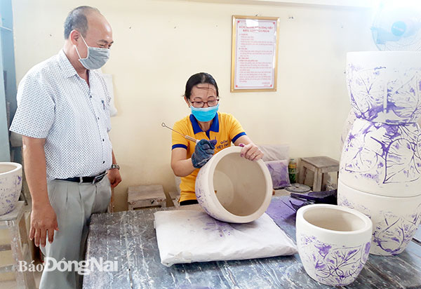 Đại diện lãnh đạo Công ty CP Gốm Việt Thành (TP.Biên Hòa) thăm hỏi công nhân làm việc tại xưởng. Ảnh: Lan Mai
