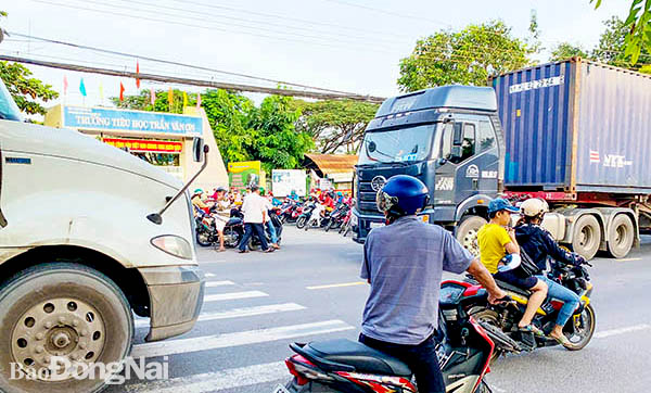 Các xe tải có trọng tải lớn lưu thông trên đường Bùi Hữu Nghĩa vào giờ cao điểm là nỗi lo cho nhiều giáo viên, phụ huynh, học sinh các trường học ven đường. Trong ảnh: Một phụ huynh băng qua đường Bùi Hữu Nghĩa để đón con tại Trường tiểu học Trần Văn Ơn. Ảnh: Đông Hồ