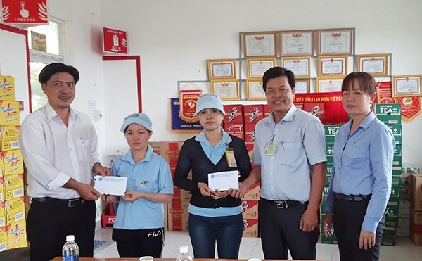 Đại diện Liên đoàn Lao động TP.Long Khánh và anh Nguyễn Tấn Hưng, Chủ tịch Công đoàn cơ sở Công ty TNHH Cibao (thứ 2 từ phải qua) trao tặng quà cho công nhân có hoàn cảnh khó khăn tại công ty