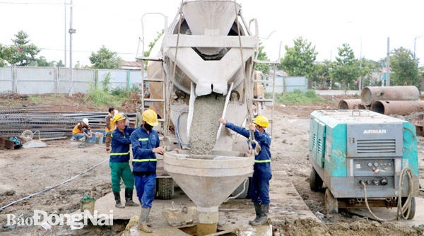 Công nhân thi công đổ bê tông hố khoan cọc nhồi tại hạng mục cầu vượt đường tỉnh 765 thuộc dự án đường cao tốc Phan Thiết - Dầu Giây. Ảnh: P.Tùng