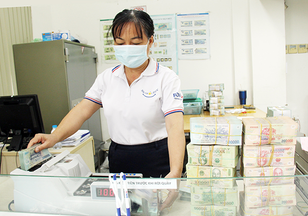 Nhân viên ngân hàng kiểm đếm tiền tại BIDV chi nhánh Biên Hòa. Ảnh: H.Quân