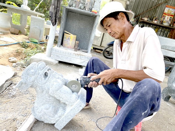 Nghệ nhân Trương Văn Bình (P.Bửu Long, TP.Biên Hòa) đang chế tác một sản phẩm từ đá xanh. Ảnh: L.Viên