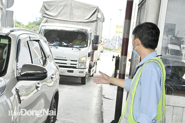 Lực lượng chức năng hướng dẫn phương tiện lưu thông qua khu vực Trạm thu phí BOT cầu Đồng Nai (quốc lộ 1, TP.Biên Hòa). Ảnh: Thanh Hải