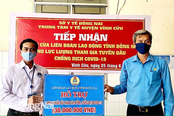 Phó chủ tịch LĐLĐ tỉnh Hồ Thanh Hồng (phải) tặng quà cho lực lượng tuyến đầu chống dịch tại khu cách ly cơ sở 2, xã Thạnh Phú, H.Vĩnh Cửu.