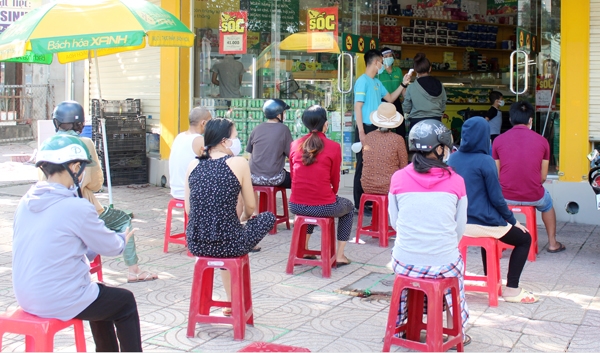 4. Tại một điểm bán thực phẩm, hàng hóa ở khu dân cư Đinh Thuận (P.Tân Hiệp), người dân xếp hàng chờ đợi và được kiểm tra y tế trước khi vào mua hàng