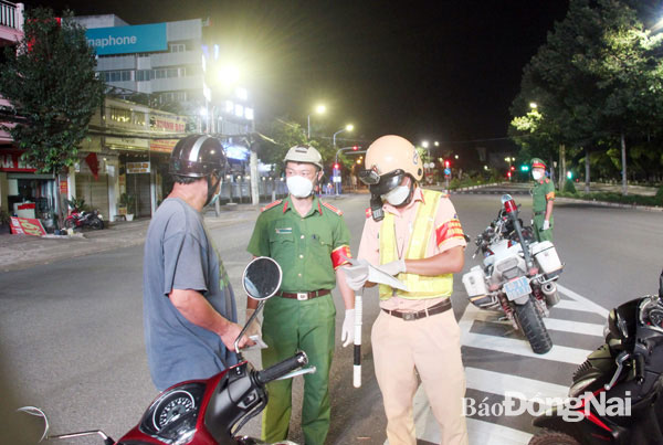 6. Lực lượng tuần tra kiểm tra giấy tờ đi đường của một người dân trên đường Phạm Văn Thuận