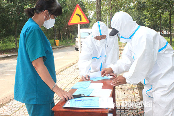 9. Điều dưỡng Lê Thị Nhàn, phụ trách điều dưỡng tại Bệnh viện Dã chiến số 3 cùng 2 tài xế rà soát lại danh sách và giấy xuất viện của các bệnh nhân để phân chia bệnh nhân vào các xe trên cùng tuyến đường