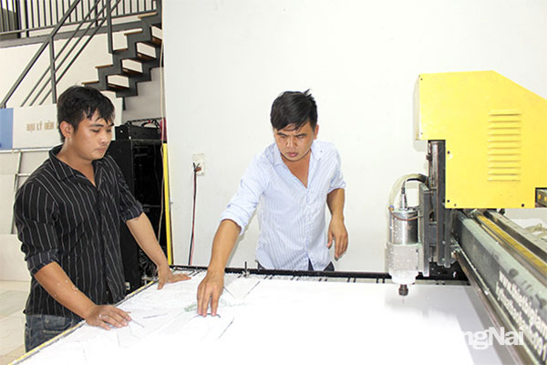 Anh Nguyễn Hải Nam (bên phải) trao đổi với nhân viên thiết kế sản phẩm. Ảnh: Vương Thế