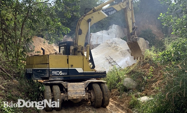 Xe máy đào thực hiện việc cuốc, cải tạo đường vào khu khai thác đá