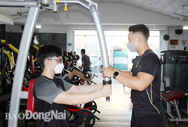 Huấn luyện viên hướng dẫn khách hàng đến tập luyện tại phòng gym Dragon Fitness Center (P.Tam Hiệp, TP.Biên Hòa). Ảnh: Hải Hà