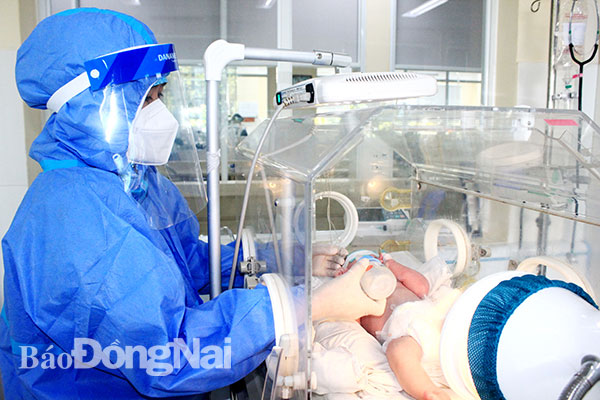 Nhân viên y tế Bệnh viện Nhi đồng Đồng Nai chăm sóc trẻ sơ sinh là con của sản phụ bị nhiễm Covid-19
