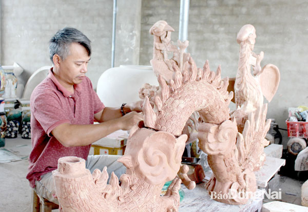Nghệ nhân Hoàng Ngọc Hiến (P.Hóa An) đang thực hiện hình tượng con rồng để phục vụ chỉnh trang, tu sửa tại các đình, chùa trên địa bàn tỉnh. Ảnh: My Ny