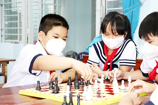 Đỗ Tấn Sang chơi cờ vua cùng bạn trong giờ ra chơi tại trường