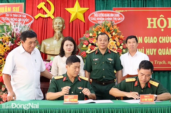 Đại tá Vũ Văn Điền và Thường trực Huyện ủy, UBND H.Nhơn Trạch chứng kiến 2 đồng chí ký biên bản giao - nhận