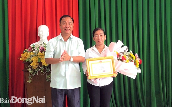 Ông Bùi Quốc Thể, Phó chủ tịch UBND TP.Long Khánh tặng giấy khen cho bà Bùi Thị Phụng (Ảnh: Minh Dũng)