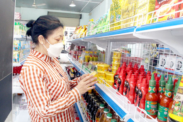 Người tiêu dùng chọn mua các sản phẩm hàng Việt tại một điểm bán hàng Tự hào hàng Việt Nam ở xã Vĩnh Thanh (H.Nhơn Trạch). Ảnh: Hải Quân
