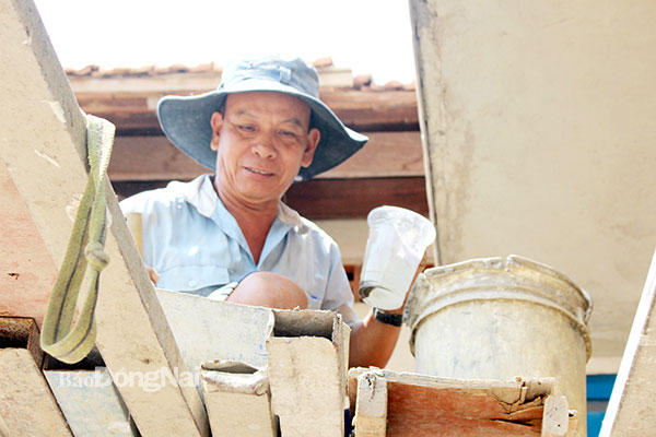 Thợ hồ Bảy Hải (64 tuổi, xã Phú Cường, H.Định Quán) miệt mài với công việc giữa trưa nắng. Ảnh: Đoàn Phú