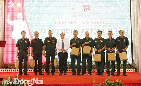 Phó bí thư phụ trách Tỉnh đoàn Nguyễn Minh Kiên tặng quà cho các cựu thanh niên xung phong tại họp mặt