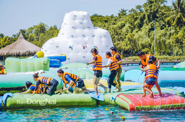 Khách du lịch tham gia trò chơi dưới nước tại Khu du lịch Suối Mơ, một điểm du lịch nổi tiếng tại H.Tân Phú. Ảnh: Thủy Mộc