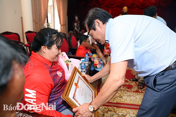 Phó chủ tịch UBND tỉnh Nguyễn Sơn Hùng tặng Bằng khen của UBND tỉnh cho VĐV Trần Thị Châu. Ảnh: Huy Anh
