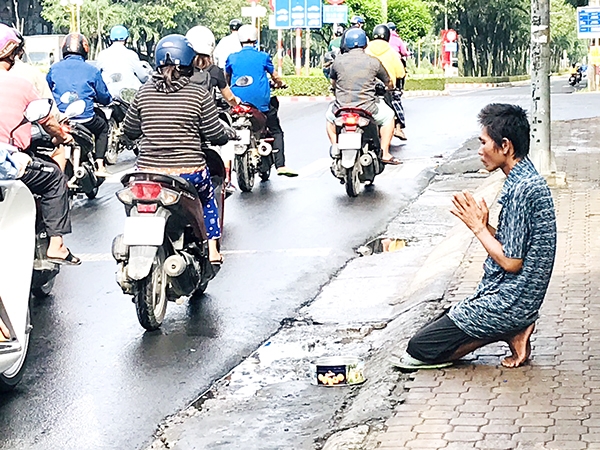 Một thanh niên quỳ lạy người đi đường để xin tiền tại góc đường vào Cổng 2 (P.Trung Dũng, TP.Biên Hòa) trông rất phản cảm